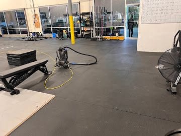 Floor scrubbing machine deep cleaning a commercial gym floor in Jacksonville